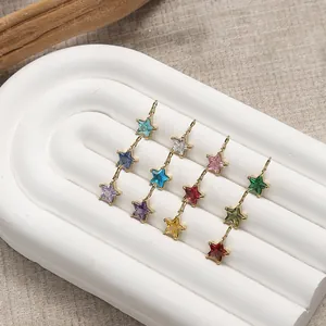 Star-shaped gold pendants with colorful gemstones arranged on a white display stand