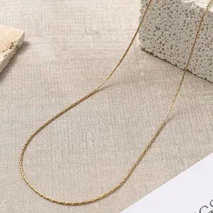 Dettaglio macro della collana a catena in acciaio placcato oro 18K su sfondo in pietra