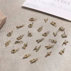 Macro shot of 26 sparkling gold-plated alphabet pendants with zircon pave settings