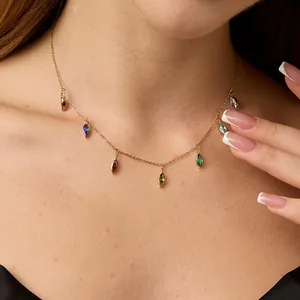 Close-up of golden necklace with multi-colored marquise-cut crystal pendants on a model