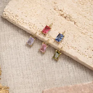 Detail of five multi-color rectangular gemstone pendants on a beige stone display