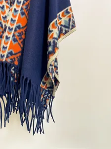 Détail du motif géométrique et des franges douces sur ce poncho d'hiver bleu marine