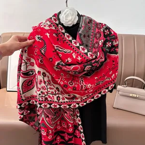 Détail d'un châle en cachemire rouge avec motifs paisley, fleurs et franges