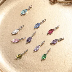 Marquise-Schliff Edelstahl-Anhänger mit bunten Edelsteinen auf goldenem Tablett