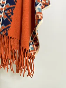 Gros plan sur un châle d'hiver épais avec motifs tribaux oranges et franges longues