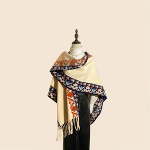 Détails d'un poncho d'hiver avec motifs ethniques et longues franges élégantes