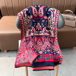 Détail du motif paisley bleu marine et rouge sur châle pashmina avec bords à franges