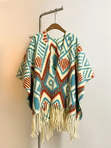 Close-up of thick knit shawl with blue geometric patterns and fringe tassels