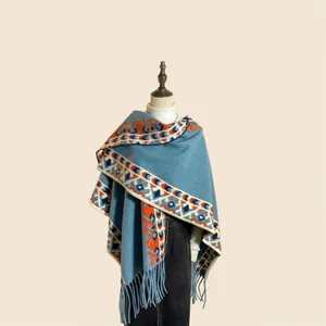 Détail du poncho à carreaux bohème avec motifs ethniques et longues franges de finition