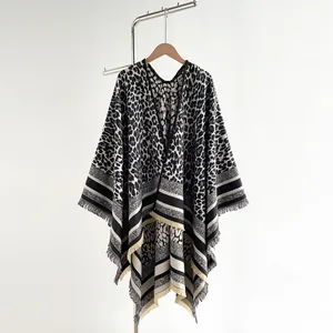 Detail of leopard print shawl featuring black stripes and elegant tassel hem finish