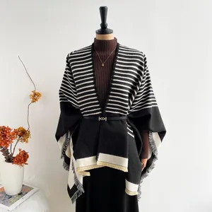 Elegant cashmere-like knit poncho with geometric stripes, fringe hem, and waist belt