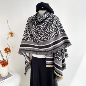 Elegant knit poncho wrap with leopard print, striped patterns and fringe trim detail