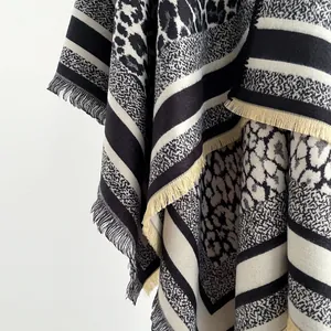 Close-up of leopard and snake print shawl with thick knit texture and fringe trim