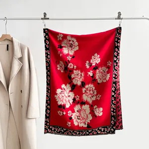 Detailed view of red floral shawl with leopard print border and soft short tassels