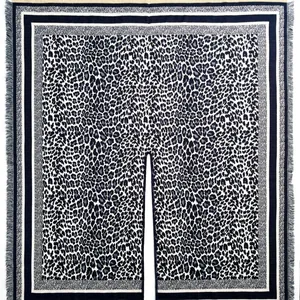 Detail of leopard print shawl featuring soft knit fabric and delicate fringe trim edges