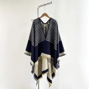 Detail of navy and beige striped knit shawl with fringe hem and V-neck opening