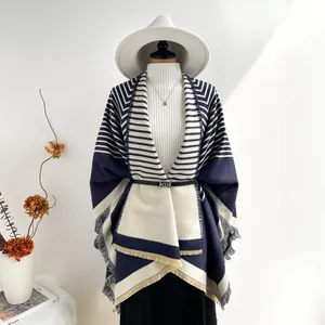 Detail of navy and beige geometric knit shawl with fringed edges and stripe pattern
