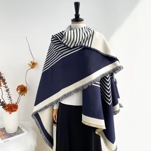Women's oversized knit shawl with blue and beige geometric patterns and fringe