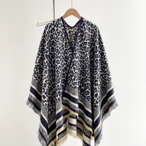 Detail of leopard print knitted shawl featuring striped hem and fringe tassels decoration