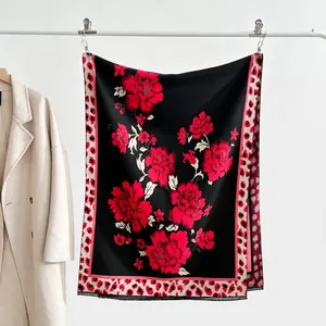 Detail of vintage jacquard scarf with red floral patterns and leopard print edges