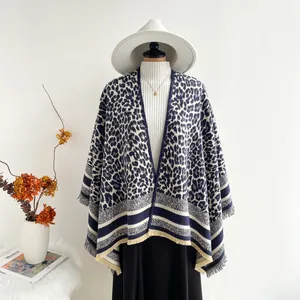 Detailed view of leopard print shawl with navy stripes and delicate fringe tassels