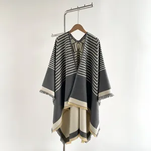 Detail of soft gray striped shawl with woven LOV collar text and fringe hem
