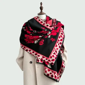 Detail of red floral and leopard print oversized shawl on a cream winter coat