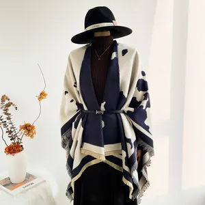 Detail of navy and cream cow pattern knit shawl featuring delicate tassel edges