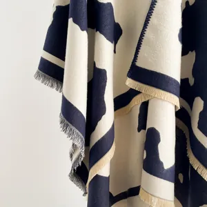 Close-up of thick cow print shawl with soft texture and delicate fringe trim details