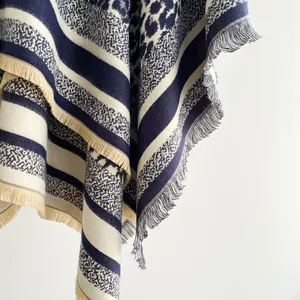 Detail view of winter cashmere-like shawl featuring blue stripes and leopard print fringes