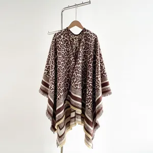 Detail view of leopard print shawl featuring contrasting striped edges and fringe tassels