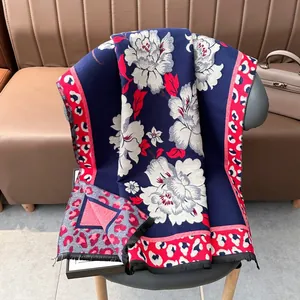 Thick vintage jacquard scarf with floral pattern and leopard trim on a grey chair
