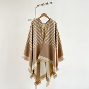 Detailed close-up of soft cashmere-like shawl featuring elegant tassels and earthy tones
