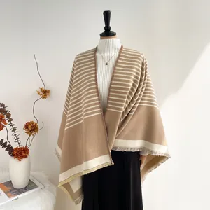 Close-up of beige and brown striped shawl with fringe details on a fashion mannequin