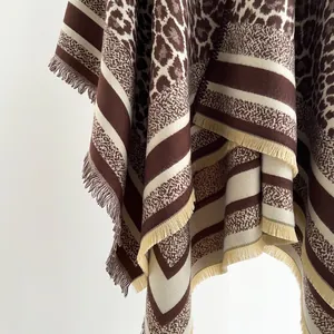 Close-up of leopard print and striped knit shawl featuring elegant fringe tassels