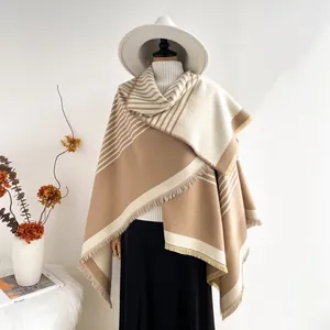 Detailed texture of beige cashmere shawl with striped pattern and long tassels