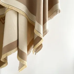 Detail of beige and brown striped cashmere-feel shawl with fine fringe tassels