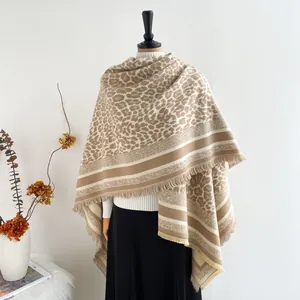 Detail of leopard print shawl with fringe edges and contrasting stripes on a mannequin