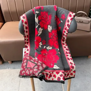 Detail of grey jacquard scarf showing red floral pattern and leopard print border