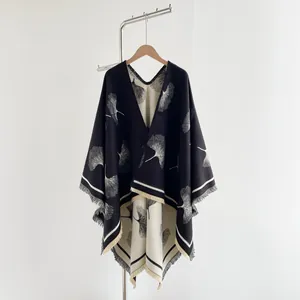 Close-up of double-sided ginkgo leaf jacquard knit shawl with tassels and contrast piping