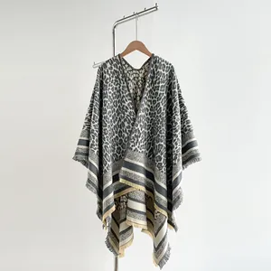 Detailed view of leopard print shawl with striped hem and fringe tassel accents