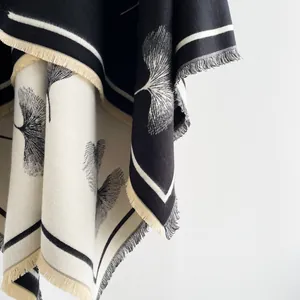Close-up of fringe edges and ginkgo leaf knit pattern on black cashmere-like shawl