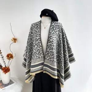 Detail of elegant leopard print shawl with fringe hem and soft knitted texture on mannequin
