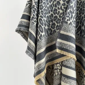 Detail of leopard print shawl with striped borders and delicate fringe tassels