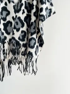 Close-up of leopard print shawl featuring thick knit texture and long tassel hem detail