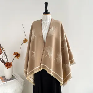 Detail of camel knit poncho featuring ginkgo leaf jacquard patterns and tassel edges