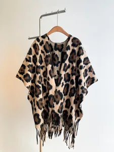 Detail of leopard print shawl with fringe trim and thick knit texture for autumn winter