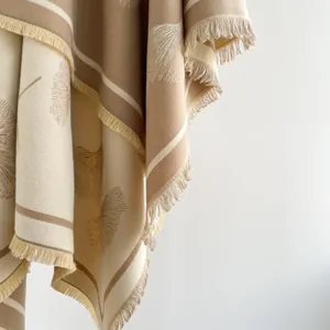 Detail of cashmere-like ginkgo leaf jacquard pattern with fine fringe tassels on a shawl