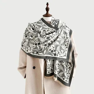 Detail of floral jacquard scarf with artistic dots, soft fringes and thick texture