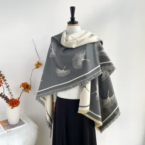 Close-up of ginkgo leaf pattern on soft cashmere-feel scarf with elegant fringe detail